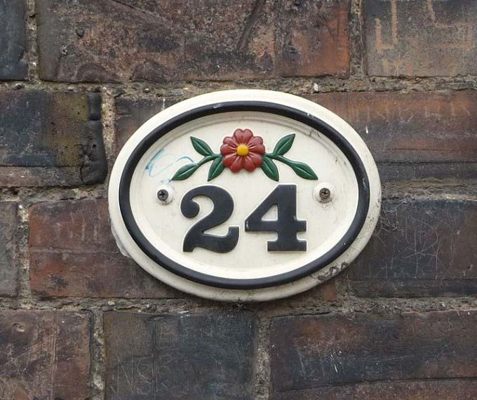 This photo shows the number 24 and a flower used as a ceramic house number.