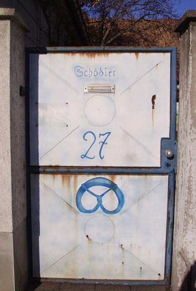 This photo shows the number 27 written on the front of an old, rusty door.