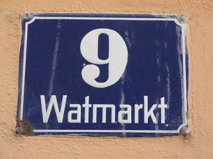 This photo shows the number 9 written in white on a blue house number plaque.